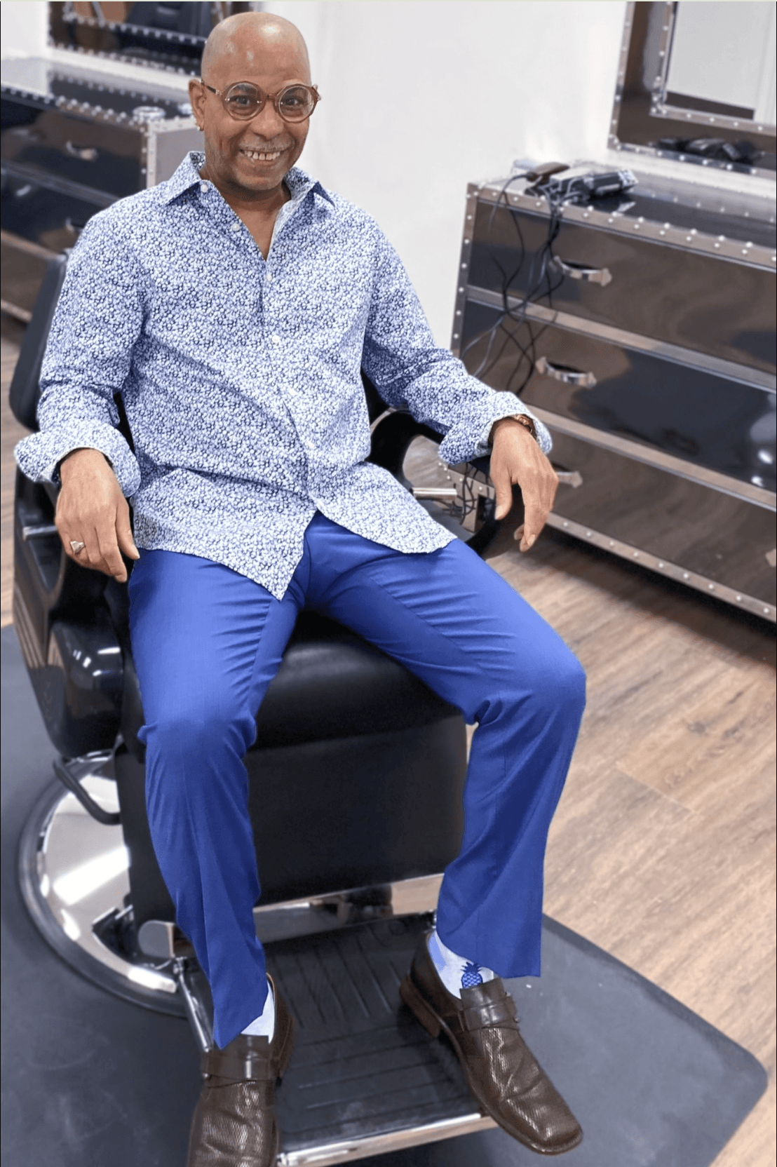 Marlon, founder of Marlon's Barbers, seated in a barber chair inside the shop
